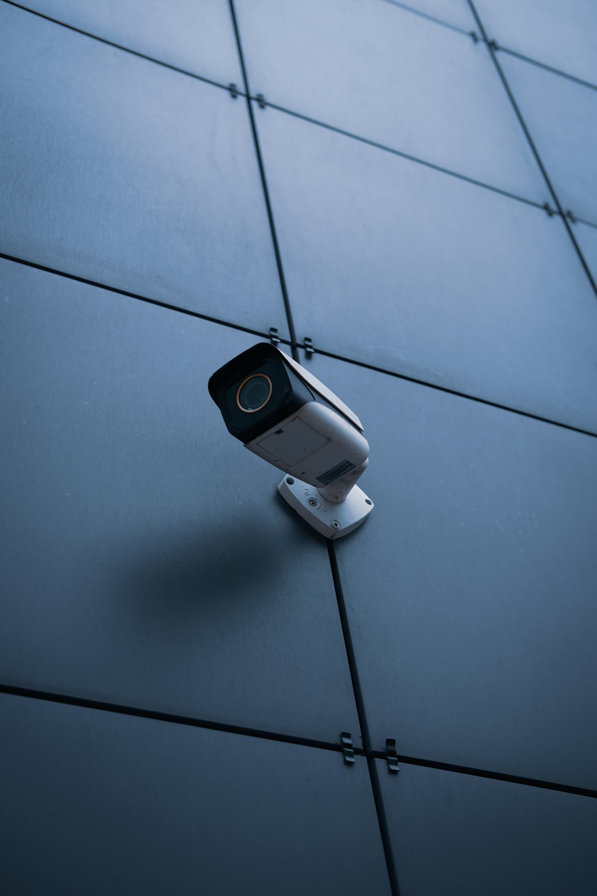 Exterior security camera mounted on a commercial glass facade